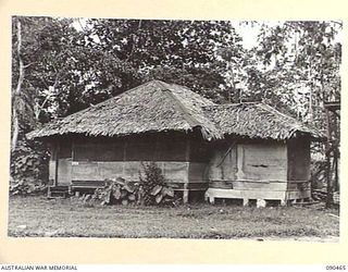 LAE, NEW GUINEA. 1945-04-08. THE OLD HUT PREVIOUSLY OCCUPIED BY THE GENERAL OFFICER COMMANDING HEADQUARTERS FIRST ARMY AND NOW USED BY THE BRIGADIER, GENERAL STAFF AND DIRECTOR OF ARMAMENT AND ..