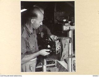 CAPE WOM, WEWAK AREA, NEW GUINEA. 1945-08-31. SIGNALMAN V. SPENCE, HEADQUARTERS ROYAL AUSTRALIAN ENGINEERS 6 DIVISION REPAIRING A 108 WIRELESS IN THE TECHNICAL SECTION