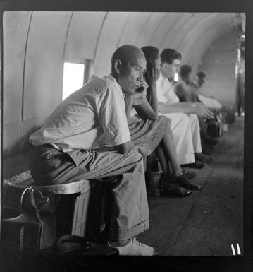 Reverend Keleher, Mr Yui and local people, on board a Qantas Empire Airways' flight from Rabaul to Manus Island, Papua New Guinea