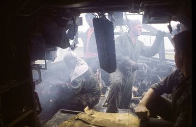 Workers take apart the cockpit of a B-52D aircraft, one of three that are being scrapped in accordance with the SALT II treaty between the United States and the Soviet Union