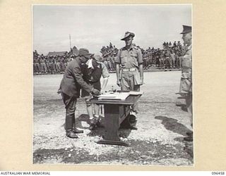 CAPE WOM, NEW GUINEA, 1945-09-13. LIEUTENANT-GENERAL H. ADACHI, COMMANDER 18 JAPANESE ARMY IN NEW GUINEA DISCUSSING THE SURRENDER TERMS WITH THE INTERPRETER. LIEUTENANT-GENERAL ADACHI FORMALLY ..