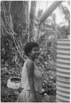 Smiling young woman, standing next to a water tank (cistern)