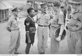 FINSCHHAFEN AREA, NEW GUINEA. 1944-04-25. MAJOR GENERAL B.M. MORRIS, DSO, GOC AUSTRALIAN NEW GUINEA ADMINISTRATIVE UNIT (1), INTRODUCING SERGEANT IWAGU, GM, ROYAL PAPUAN CONSTABULARY (2), TO THE ..