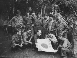 DUMPU, RAMU VALLEY, NEW GUINEA, 1944-02-11. MEMBERS OF NO.10 PLATOON, "B" COMPANY, 57/60TH INFANTRY BATTALION, EXAMINING A CAPTURED JAPANESE FLAG. IDENTIFIED PERSONNEL ARE: VX136083 PRIVATE V.C. ..