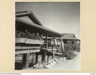 PORT MORESBY, NEW GUINEA. 1944-05-22. AN EXTERIOR VIEW OF THE LOUNGE ROOM OF THE OFFICERS' CLUB AT ELA BEACH. THE BUILDINGS, ORIGINALLY NATIVE HOSPITALS, ARE POSITIONED ON PYLONS ABOVE THE SEA