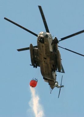 A US Marine Corps (USMC) CH-53D Super Stallion helicopter, Marine Heavy Helicopter Squadron 363, Kaneohe Bay, Hawaii (HI), prepares to drop more than 2,000 gallons of water on a brushfire on the island of Oahu, HI. The Department of Defense (DoD) supplied eight helicopters and the Federal Fire Department (FFD) supplied nine fire engines to aid the Honolulu Fire Department (FD) in extinguishing the blaze, that consumed more than 3,000 acres