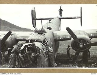 FAITA, NEW GUINEA. 1944-01-07. MEMBERS OF THE 2/2ND COMMANDO SQUADRON LOOKING OVER A LIBERATOR (B-24) WHICH CRASHED ON THE AIRSTRIP RETURNING FROM A RAID ON WEWAK. IDENTIFIED PERSONNEL ARE: TROOPER ..