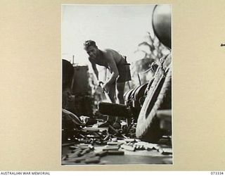 KARKAR ISLAND, NEW GUINEA. 1944-05-18. ABLE SEAMAN C.L. GLEDHILL, RAN, SWEEPING SHELL CASES DOWN THE DECK OF ONE OF HMA MOTOR LAUNCHES AFTER THE PRE- INVASION BOMBARDMENT OF JAPANESE POSITIONS ON ..