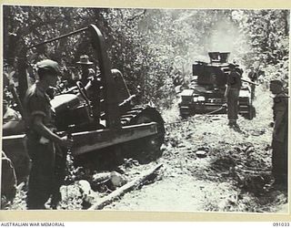BOUGAINVILLE. 1945-04-17. A BOGGED BULLDOZER OF 15 FIELD COMPANY ROYAL AUSTRALIAN ENGINEERS BEING TOWED BACK TO THE ROAD BY MATILDA TANKS. IT WAS MAKING A CROSSING FOR MATILDA TANKS OVER DAWE ..