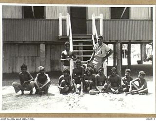 MILLINGIMBI ISLAND, NT. 1943-11-18. REVEREND KOLINIO N. SAUKURU, A FIJIAN METHODIST MISSIONARY WITH HIS HOUSE BOYS AND GIRLS IN FRONT OF HIS MISSION HOUSE