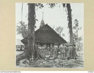 LAE, NEW GUINEA. 1944-09-29. SERVICE PERSONNEL GATHERED AROUND THE NEW CHAPEL AT HEADQUARTERS, NEW GUINEA FORCE AWAITING THE ARRIVAL OF THE GENERAL OFFICER COMMANDING NEW GUINEA FORCE FOR THE ..