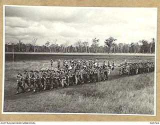 WONDECLA, QLD. 1944-04-15. NX4120 LIEUTENANT C.S. BROWN, OFFICER- IN- CHARGE, HEADQUARTERS COMPANY, 2/1ST INFANTRY BATTALION, LEFT (2) GIVE "EYES RIGHT" AS HQ. COMPANY MARCH PAST THE COMMANDING ..
