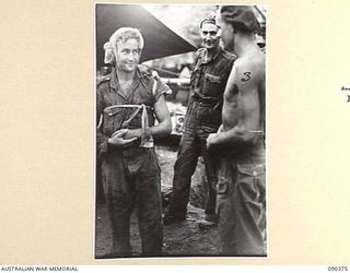 PRIVATE CURRIE, 25 INFANTRY BATTALION (1) OF TAREE, NSW, WOUNDED IN ACTION DURING THE UNSUCCESSFUL JAPANESE ATTACK AGAINST SLATER'S KNOLL, SPEAKING WITH MATES AT THE REGIMENTAL AID POST AT ..