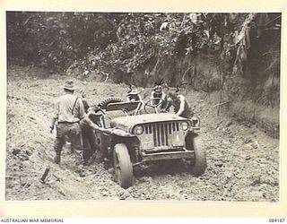 BOUGAINVILLE, SOLOMON ISLANDS. 1944-12-08. SAPPERS FROM 5 AND 11 FIELD COMPANY, ROYAL AUSTRALIAN ENGINEERS, ASSISTING A BOGGED JEEP. IDENTIFIED PERSONNEL ARE:- CAPTAIN DUNCAN, HQ RAE, 3RD DIVISION, ..