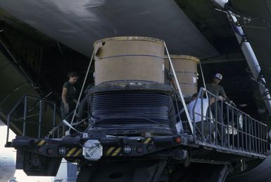 Members of the 22nd Military Airlift Squadron load pallets of electrical cable into a C-5 Galaxy aircraft headed for Pago Pago, American Samoa