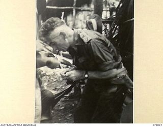 IDAKAIBUL, NEW GUINEA. 1945-01-23. VX17 MAJOR GENERAL J.E.S. STEVENS, DSO, ED, GENERAL OFFICER COMMANDING 6TH DIVISION GETS A LIGHT FOR HIS CIGARETTE ON HIS ARRIVAL AT THE DETAILS ISSUAING DEPOT ..