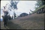 Pig festival, singsing preparations, Tuguma: men rehearse a song, watched by women and children