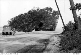 TADJI AIRSTRIP, AITAPE, NEW GUINEA. 1944-05-26. 30542 FLYING OFFICER HENRY ARTHUR HURST, NO. 100 SQUADRON RAAF, WITH THE COMMAND CAR BELONGING TO NO. 8 SQUADRON RAAF WHICH HE HAD `STOLEN' AFTER ..