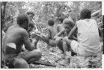 Men and boys eat a sacrificial meal in a shrine