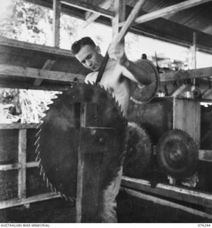 LAE, NEW GUINEA. 1944-09-27. A MEMBER OF THE 43RD FIELD ORDNANCE DEPOT SHARPENING A 36 INCH CIRCULAR SAW AT THE UNIT MILL