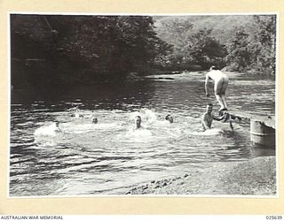 PORT MORESBY, PAPUA. 1942-07. RELAXING AFTER A LONG ROUTE MARCH, AUSTRALIAN TROOPS ENJOY THE FRESHNESS OF A NEW GUINEA MOUNTAIN STREAM