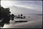 Manus: dawn at Pere bay, tethered canoes, houses and outhouses over calm lagoon