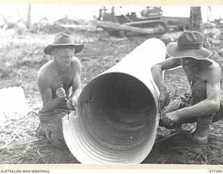 PALMALMAL PLANTATION, NEW BRITAIN. 1944-11-29. N237891 CORPORAL J.V.DE COQUE (1) AND N28077 SAPPER C.B. ROBERSON (2) OF THE 17TH FIELD COMPANY, 48TH DEPUTY COMMANDER, ROYAL ENGINEERS (WORKS) MAKING ..