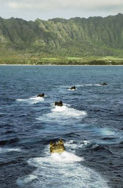 US Marine Corps (USMC) AAV7A1 Amphibious Assault Vehicles assigned to the 3rd Amphibious Assault Battalion maneuver through the waters of the Pacific Ocean, as they head toward the beach at Training Area Bellows, Hawaii to conduct infantry and amphibious training