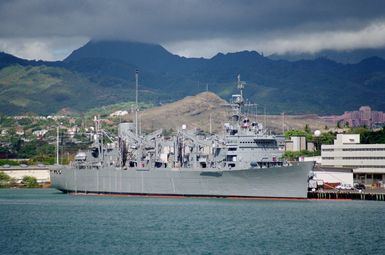 Starboard bow view of the fast combat support ship USS CAMDEN (AOE 2) tied up at the Naval Supply Depot, Berth Kilo no. 10. The ship is taking part in Operation RIMPAC 2000. To the far right, up in Aiea Heights can be seen the Tripler Army Hospital of the Pacific