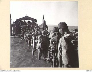 WEWAK AREA, NEW GUINEA. 1945-09-21. MEMBERS OF 18 JAPANESE ARMY WADING THROUGH THE SURF TO THE BARGE FOR MOVEMENT TO THE CONCENTRATION AREA ON MUSCHU ISLAND. THE JAPANESE HAVE BEEN SEARCHED AT A ..