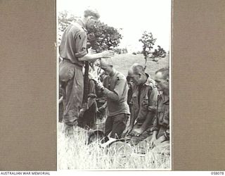 RAMU VALLEY, NEW GUINEA. 1943-10-20. SX11061, PADRE H. NORMAN, (CHURCH OF ENGLAND), ADMINISTERS HOLY COMMUNION TO CORPORAL R. JACKSON (2); CORPORAL G.W. LANE (3); CORPORAL L. JACKSON (4)