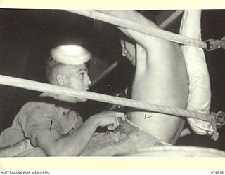 LAE, NEW GUINEA. 1944-07-22. PRIVATE SWEENEY (SECOND) (1) ATTENDING TO PRIVATE SAM MOY (UNITED STATES OF AMERICA) (2) DURING THE INTERVAL BETWEEN ROUNDS DURING A BOXING TOURNAMENT BETWEEN ..