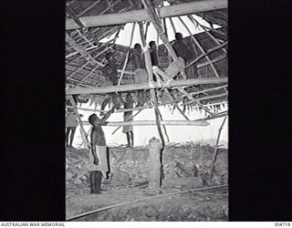 SEGI, NEW GEORGIA, BRITISH SOLOMON ISLANDS PROTECTORATE. C.1944. LOCAL NATIVES BUILD A COVERED EMPLACEMENT FOR COASTWATCHER DONALD KENNEDY. (NAVAL HISTORICAL COLLECTION)