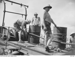 BOERA POINT, NEW GUINEA. 1943-10-01. THE FIRST STAGES OF LAYING A CABLE BETWEEN PORT MORESBY AND CAPE YORK IS TO ANCHOR THE SHORE END OF THE CABLE. HERE MEMBERS OF THE CREW OF THE SS MERNOO, AND ..
