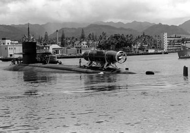 A port quarter view of the nuclear-powered attack submarine USS CAVALLA (SSN-684) with the deep submergence rescue vehicle AVALON (DSRV-2) attached. The CAVALLA and AVALON are taking part in a fly-away exercise to train personnel in the handling and operation of the DSRV