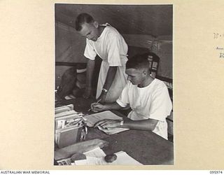 CAPE WOM, WEWAK AREA, NEW GUINEA. 1945-09-01. MAJOR D.R. HEDBERG, COMMANDING OFFICER 2/4 DENTAL UNIT ATTACHED HEADQUARTERS 6 DIVISION (1) AND CAPTAIN V.J. TAYLOR, SECOND IN COMMAND (2), DISCUSSING ..