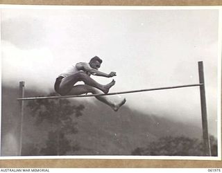 17 MILE, PORT MORESBY AREA, NEW GUINEA. 1943-12-25. PRIVATE MCKENZIE, WINNER OF THE HIGH JUMP, ATTEMPTS 5' 4" AT THE 10TH AUSTRALIAN ADVANCED ORDNANCE DEPOT SPORTS MEETING