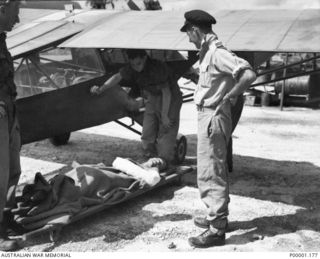 THE SOLOMON ISALNDS, 1945. A WOUNDED AUSTRALIAN SOLDIER ON BOUGAINVILLE ISLAND READY TO BE CARRIED AWAY FOR TREATMENT. THE SOLDIER HAD BEEN EVACUATED BY RAAF AUSTER AIRCRAFT A11-3. (RNZAF OFFICIAL ..