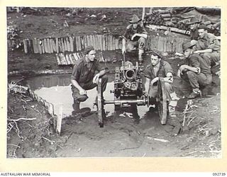 SORAKEN, BOUGAINVILLE. 1945-06-02. NO. 1 GUN OF 2 MOUNTAIN BATTERY WITH ITS CREW IN POSITION. NOTE THE FLOODED GUN PIT