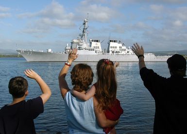 Family members wave good-bye to their loved ones onboard the US Navy (USN) Arleigh Burke Class (Flight IIA) Guided Missile Destroyer (AEGIS), USS OKANE (DDG 77) as she departs Pearl Harbor, Hawaii (HI), as part of a regularly scheduled around the world deployment with the USN Nimitz Class Aircraft Carrier, USS CARL VINSON (CVN 70) Carrier Strike Group (CSG)