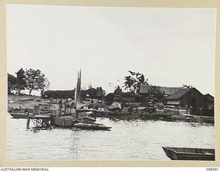 SALAMAUA, NEW GUINEA. 1945-11-03. THE WHARF AREA OF 2 MARINE FOOD SUPPLY PLATOON, VIEWED FROM A 40-FOOT BOAT LEAVING FOR LAE