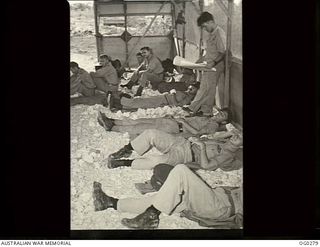 VIVIGANI, GOODENOUGH ISLAND, PAPUA. C. 1943-05-29. BEAUFIGHTER CREWS OF NO. 30 SQUADRON RAAF RELAX ON THE CORAL FLOOR OF A HUT. THEY ARE ON STANDBY AND READY TO TAKE OFF AT A MOMENT'S NOTICE. (SAME ..