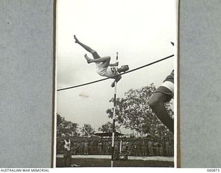 NEW GUINEA. 1943-11-20. PRIVATE GORMAN, 2/12TH AUSTRALIAN INFANTRY BATTALION, WINNER OF THE EVENT, CLEARING THE BAR AT NINE FEET AND FOUR INCHES IN THE POLE VAULT AT THE SPORTS MEETING ORGANISED BY ..