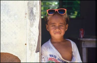 Child wearing pink framed sunglasses