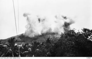 PORT MORESBY, NEW GUINEA. 1942-03-19. THICK SMOKE BILLOWS UP FROM TUAGUBU HILL AFTER A JAPANESE AIRCRAFT ATTACK AGAINST A 3.7 INCH ANTI-AIRCRAFT BATTERY