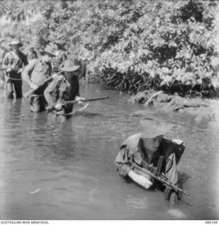SIAR, NEW GUINEA. 1944-07-04. VX148667 PRIVATE L.T. TREMAYNE, 57/60TH INFANTRY BATTALION, 15TH INFANTRY BRIGADE (3), SINKS INTO MUD WITH THE WEIGHT OF HIS EQUIPMENT AND OWEN GUN. V45615 PRIVATE E. ..