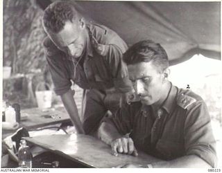 DUGUMUR, NEW GUINEA. 1944-07. NX112661 LIEUTENANT-COLONEL P.W. CROSKY, COMMANDING OFFICER 4TH INFANTRY BATTALION (2), WITH HIS ADJUTANT NX112666 CAPTAIN H.R. BEARDSMORE (1)