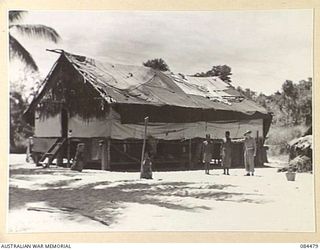 LAE, NEW GUINEA. 1944-12-18. THE NATIVE QUARTERS OF THE 195 NATIVE PERSONNEL AT HQ 12 SMALL SHIP COY. THE COY CONSISTS OF 25 OFFICERS AND 195 OTHER RANKS. THE NATIVES ARE ATTACHED FOR USE ON THE ..