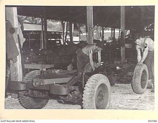 PALMALMAL PLANTATION, JACQUINOT BAY, NEW BRITAIN, 1945-06-06. CRAFTSMAN MCENTEE (1) AND SERGEANT S.K. PATTERSON (2), MEMBERS OF 1 INFANTRY TROOPS WORKSHOP AT WORK ON THE 'WILLOW RUN', AN ASSEMBLY ..