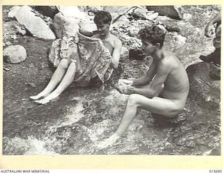 1943-09-14. NEW GUINEA. WASHING DAY IN THE SALAMAUA AREA A HARD FIGHT ON THE KOMIATUM RIDGE. L/CPL. COLIN HOBBA OF BROKEN HILL, N.S.W. AND SIG. HAROLD MASTERS, OF BRUNSWICK, VIC., WASHING BOTH ..